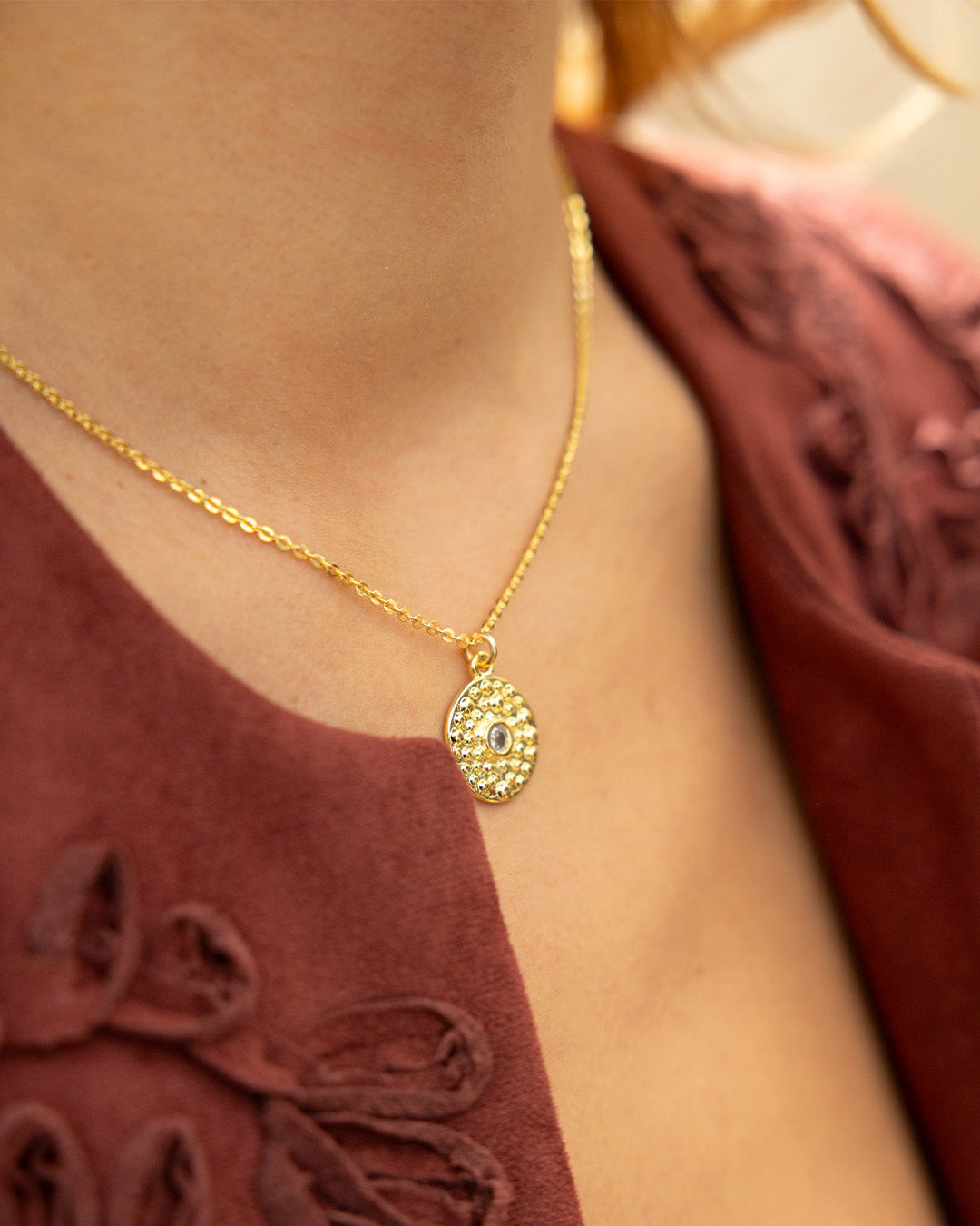 Mujer luciendo el collar Alma con dije redondo con cristal 