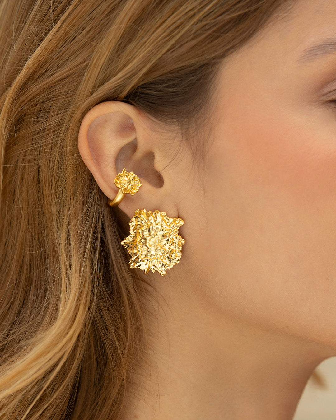 Acercamiento a oreja de mujer luciendo el earcuff Caleana con diseño de hoja martillada
